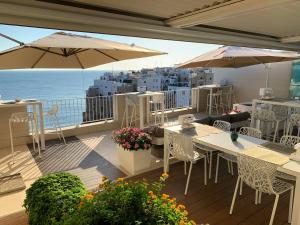 滨海波利尼亚诺马陆住宿加早餐酒店的阳台配有桌子和遮阳伞,享有海景。