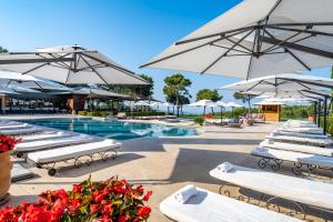 勒卡斯特雷特卡斯特雷特酒店及Spa的一个带白色躺椅和遮阳伞的游泳池