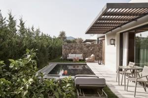 梅松吉The Olivar Suites的后院设有游泳池、桌子和椅子