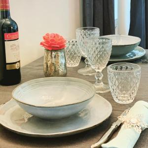 BeckerichIsabelle's Rosegarden的一张带盘子和玻璃杯的桌子和一瓶葡萄酒