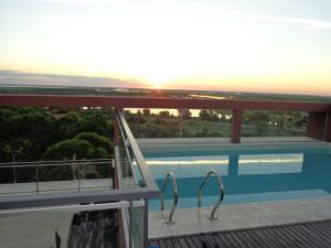 维多利亚Rio Manso Apart Hotel的从带游泳池的房屋阳台欣赏风景