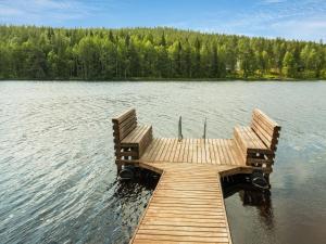 SonkaHoliday Home Karpalo by Interhome的湖上带两个长椅的木甲板