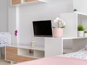 圣费德洛斯博利什Studio Lorna by Interhome的一间白色卧室,配有电视和书桌