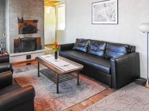 LannevesiHoliday Home Pusula by Interhome的客厅配有黑色真皮沙发和桌子