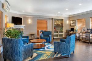 新港Elizabeth Oceanfront Suites, Ascend Hotel Collection的客厅配有蓝色的椅子和桌子