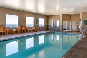 新港Elizabeth Oceanfront Suites, Ascend Hotel Collection的一座配有桌椅的酒店游泳池