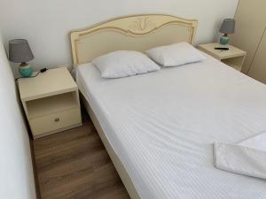 敖德萨Appartments near 7 km 5001155的一间卧室配有两张床,还有一个床头柜和两盏灯。