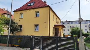 弗罗茨瓦夫Apartament przy Wrocławskim Stadionie的黄色的房屋,有红色的屋顶