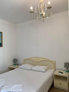 敖德萨Appartments near 7 km 5001155的卧室配有白色的床和吊灯。