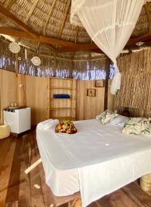 普雷亚Cabanadu Preá Kite的一间卧室配有一张白色大床,床上有鲜花