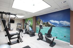 贝尼多姆贝尼多姆赫利奥斯酒店的一个带健身器材和海洋壁画的健身房