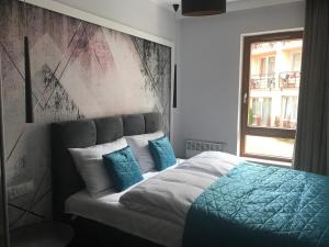库瑞尼卡慕斯卡APARTAMENT D-7 W OBIEKCIE NAUTIKKA PARK的一间卧室配有一张带蓝色枕头的床