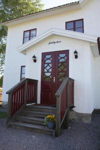 蒂纳Jaktlyckan, Tuna Gård的白色的房子,有红色的门和楼梯