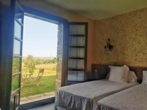 Cefontes卡瑟纳赛冯特乡间酒店的一间卧室设有一张床和一个大窗户