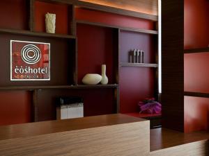 莱切Eos Hotel的更衣室设有红色的墙壁和木桌