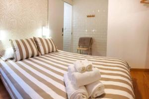 卡塞雷斯El Escondite de la Muralla的一间设有床铺和毛巾的房间
