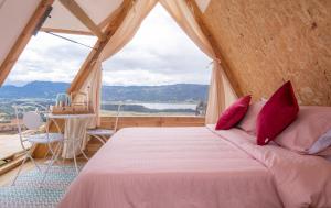 瓜塔维塔Andes Glamping的一间卧室设有一张床和一个大窗户