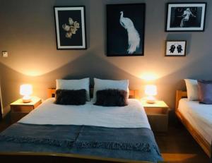 萨拉热窝科尔诺酒店的卧室配有一张带两盏灯的床,墙上挂着一只猫