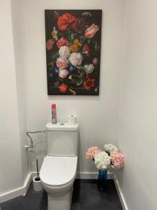 那慕尔The Pink Studio - Exceptional location IN city center - Unique & Elegant的浴室设有白色卫生间,墙上挂有绘画作品
