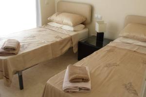 穆尔西亚Roda Golf & Beach Resort. Townhouse, Poolside的客房内的两张床和毛巾