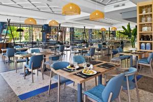 马拉喀什Hotel Riu Tikida Garden - All Inclusive Adults Only的餐厅设有木桌和蓝色椅子