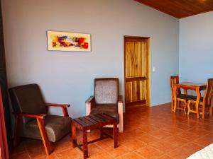 蒙泰韦尔德哥斯达黎加Sunset Vista Lodge,Monteverde,Costa Rica.的客厅配有椅子、桌子和椅子