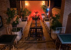 马拉喀什罗曼斯庭院旅馆的一间配备有沙发、桌子和盆栽植物的房间
