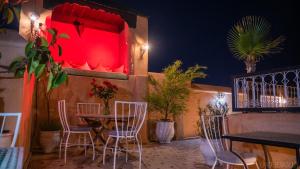 马拉喀什罗曼斯庭院旅馆的一间带桌椅和红灯的餐厅