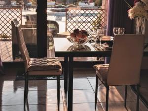 尼亚·蒙达尼亚Villa Scorpion Nea Moudania Halkidiki的餐桌,配有两把椅子和一碗水果