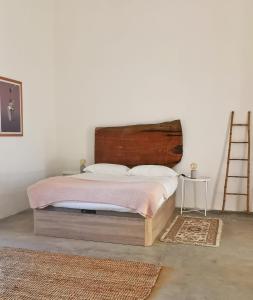 São BrissosTorre da Giesteira的一间卧室配有一张带木制床头板和梯子的床。