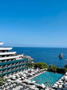 丰沙尔Enotel Lido - All Inclusive的享有带游泳池和大海的度假胜地的景致