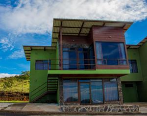 蒙泰韦尔德哥斯达黎加Sunset Vista Lodge,Monteverde,Costa Rica.的绿色房子的顶部设有阳台