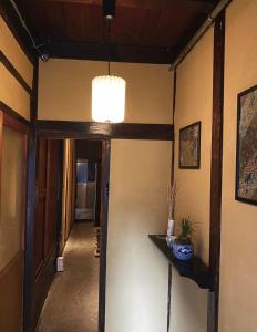 名古屋Machiya Kikunoya的走廊上有一扇门,房间还有吊灯
