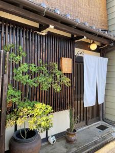 名古屋Machiya Kikunoya的一条毛巾挂在两棵植物的围栏上