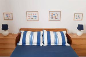 波尔蒂芒Cozy beach front apartment的一间卧室配有一张带蓝色和白色枕头的床