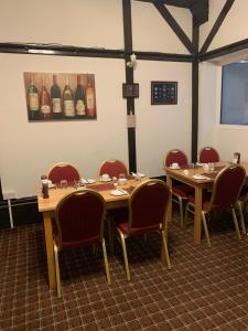 布莱克浦都铎酒店的一间设有桌椅和瓶装葡萄酒的用餐室