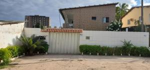 保利斯塔Ap07-A 50 Metros da Praia Flats Completamente Mobiliados的一座带白色围栏和车库的房子