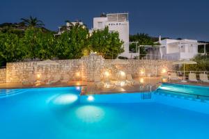 干尼亚Eolos Apartments的享有游泳池的夜间景致