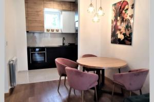 诺维萨德SNP city center lux的厨房配有木桌和紫色椅子