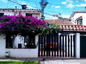 波哥大Casa Turística Camitas Inn的 ⁇ 上花紫色的白色房子