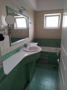雅典Σύγχρονο Vintage στο Μαρούσι的浴室配有盥洗盆、镜子和浴缸