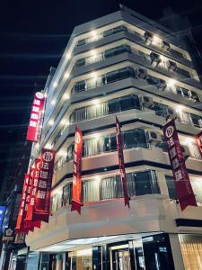 台中市法堤商旅的一座高大的白色建筑,上面有红色标志