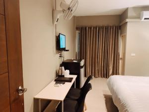 乌隆他尼Kangaroo Residence Udonthani的酒店客房配有书桌和床。
