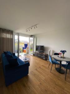 格丁尼亚Apartament Wiczlino的客厅配有蓝色的沙发和桌子