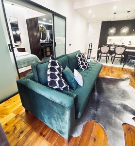 马德里Apartamento de diseño en Malasaña junto a Gran Vía的客厅配有带枕头的绿色沙发