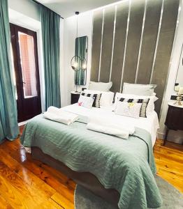 马德里Apartamento de diseño en Malasaña junto a Gran Vía的一间卧室配有一张带绿色和白色枕头的大床