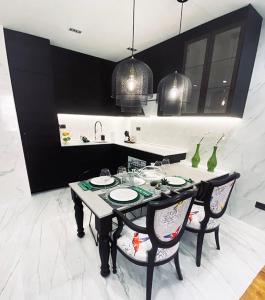 马德里Apartamento de diseño en Malasaña junto a Gran Vía的厨房配有带2把椅子的桌子和水槽