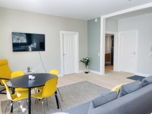奥尔堡aday - 2 bedroom with modern kitchen and free parking的客厅配有沙发、桌子和黄色椅子