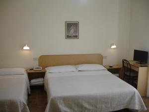 贾迪尼-纳克索斯Hotel La Rusticana的酒店客房设有两张床和电视。
