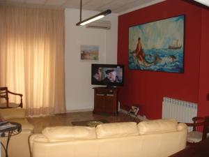 贾迪尼-纳克索斯Hotel La Rusticana的客厅配有白色沙发和平面电视。